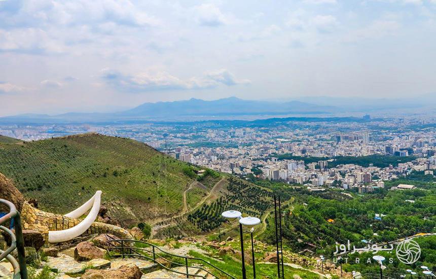 پارک جمشیدیه تهران؛ منظره پارک از بالا که مشرف به تپه‌هایی سرسبز و نمایی از شهر است. 